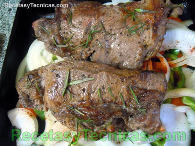 Cortes de carne sobre colchón de vegetales